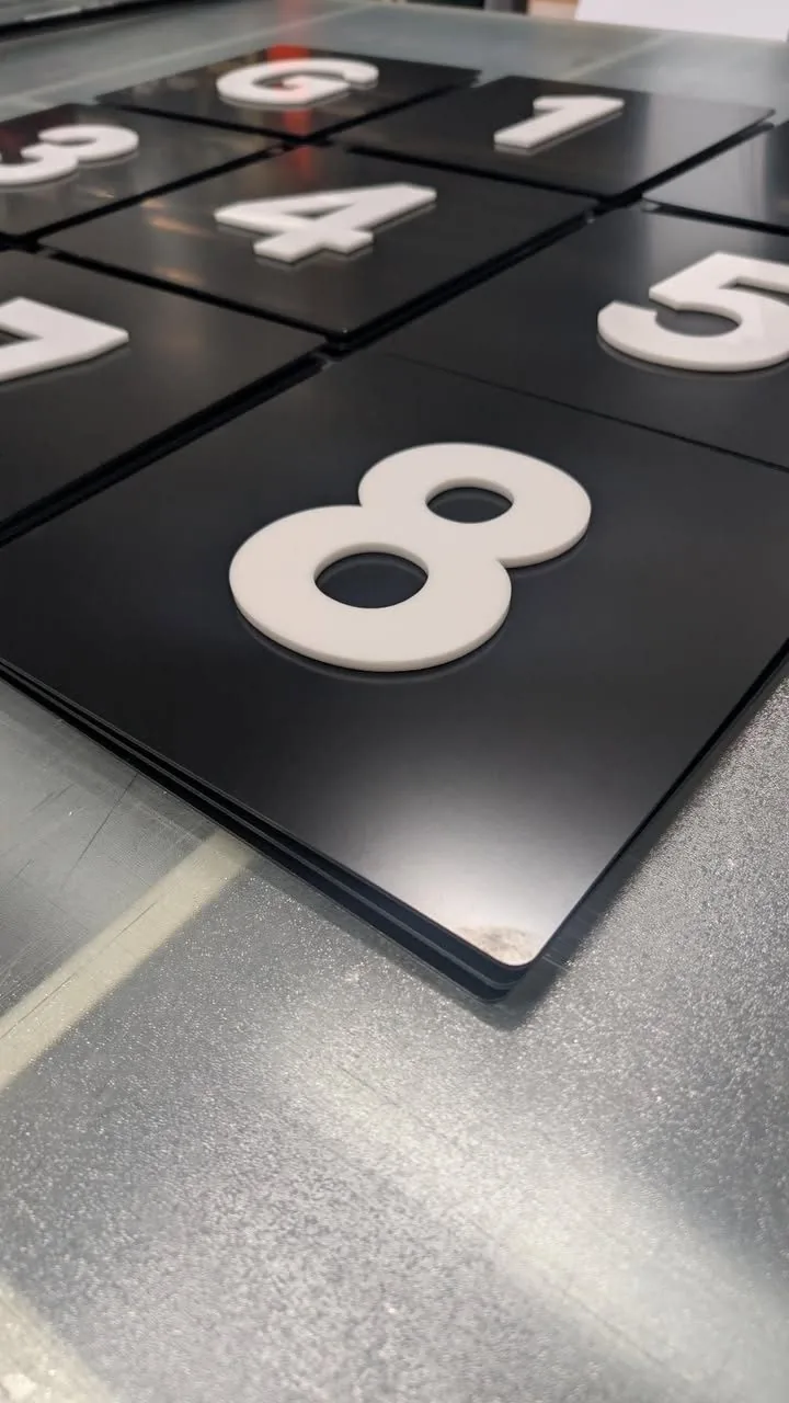 Batch of 3D room-number door signs during fabrication