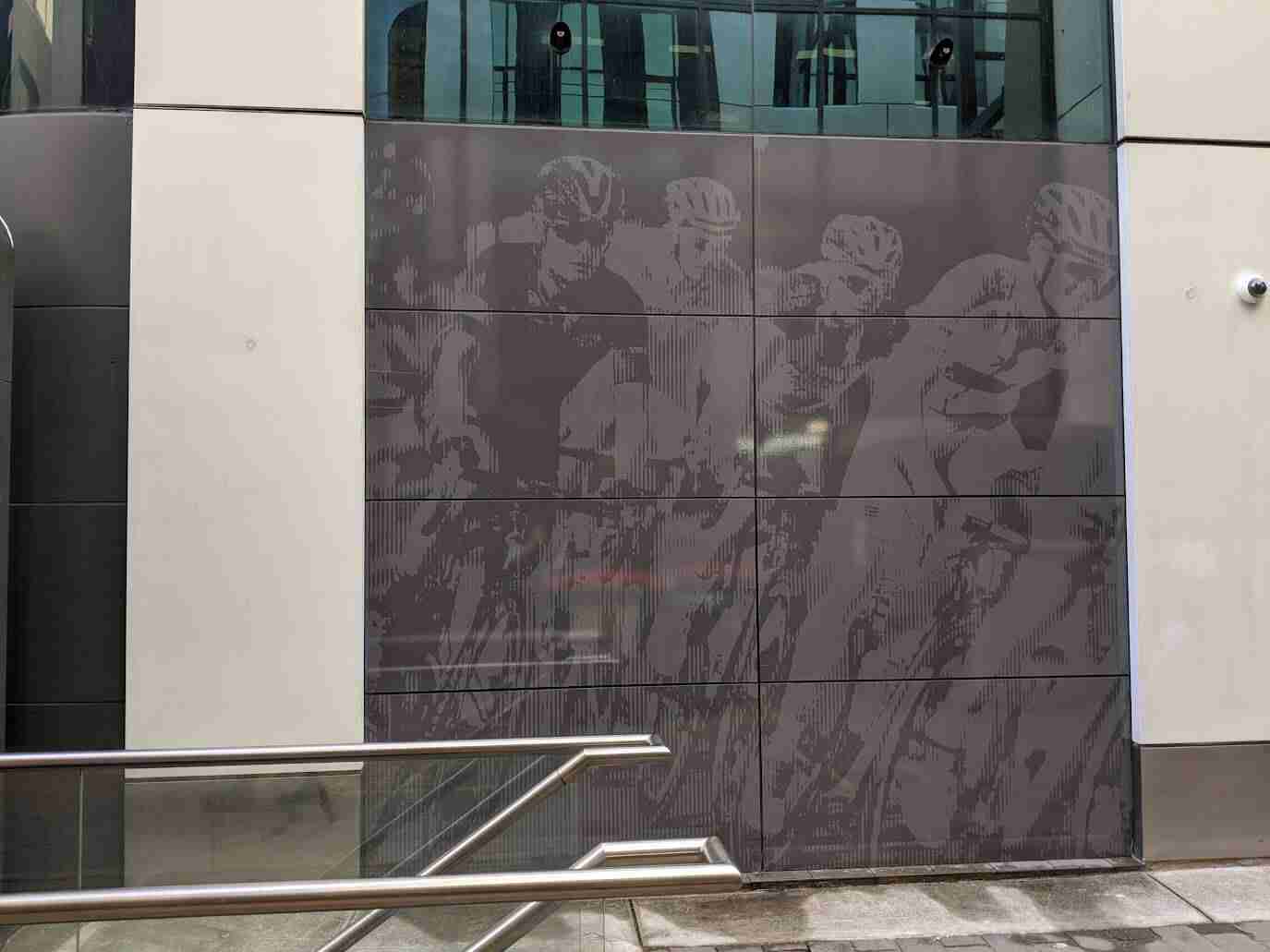 Large grey-toned sports-themed wall graphic installed on commercial exterior