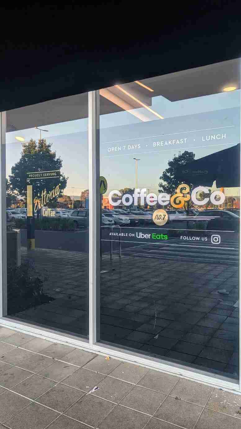 Close-up of Coffee & Co window graphics with logo and business information