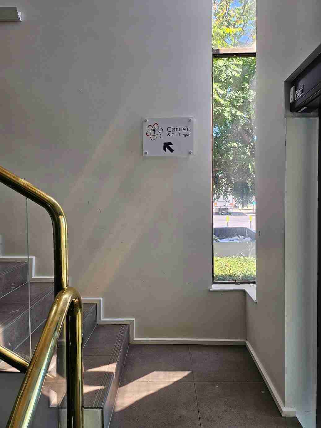 Wall-mounted directional sign in stairwell showing path to amenities