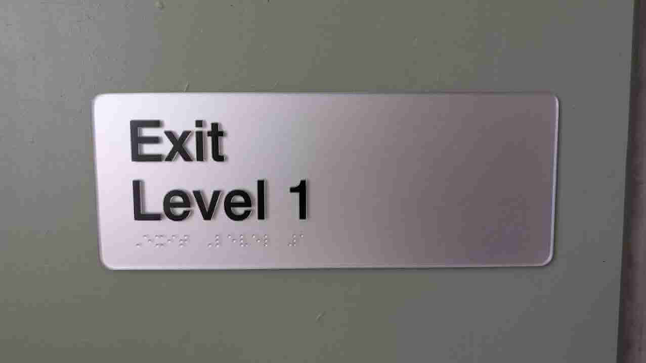 Exit Level 1 safety and directional sign on interior wall