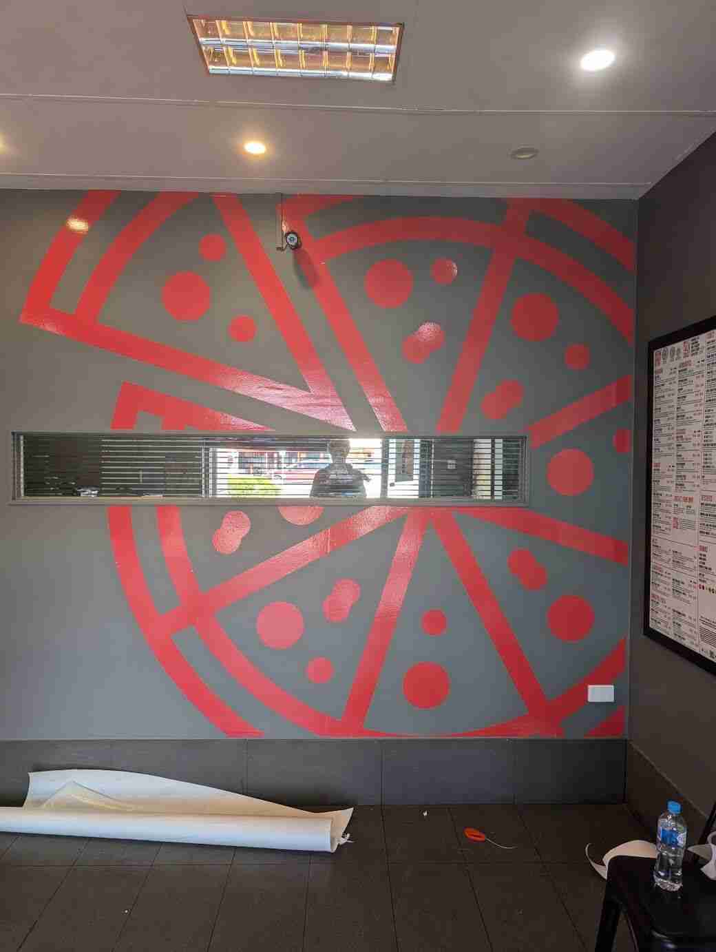 Red geometric wall graphic creating bold interior feature wall design