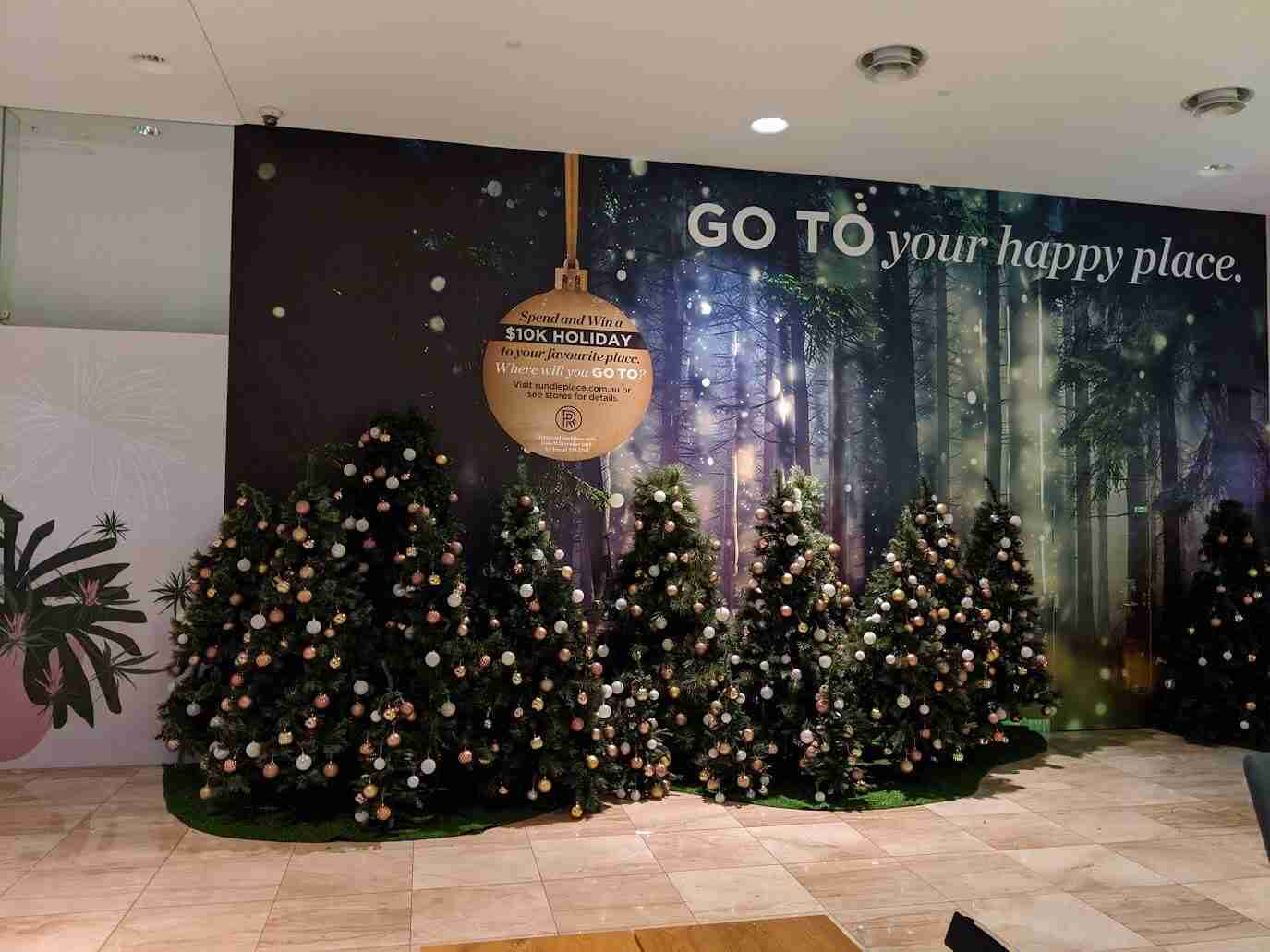 Shopping centre Christmas display featuring wall graphic and decorated trees