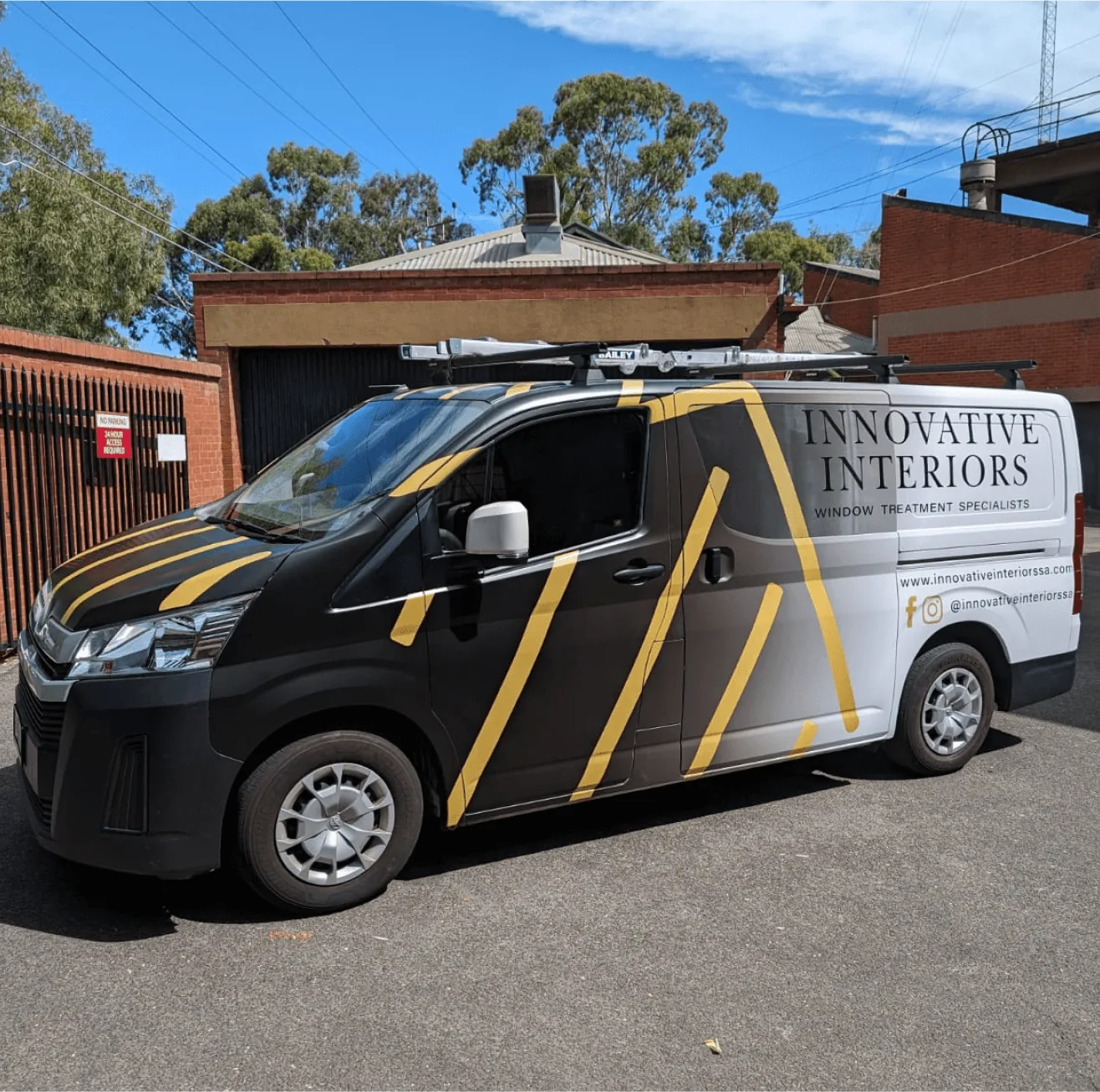 Black commercial van with yellow diagonal stripe vehicle wrap