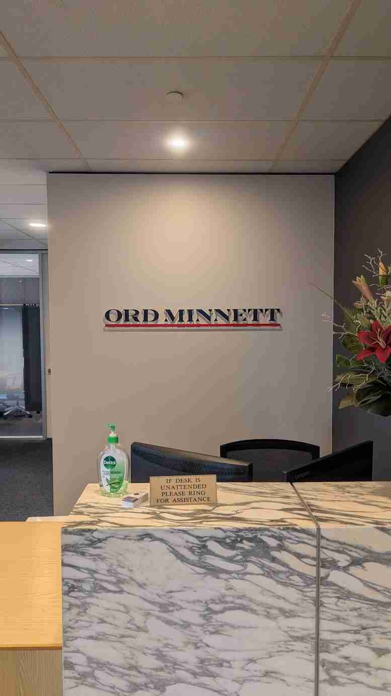 Ord Minnett metallic reception wall sign installed behind front desk