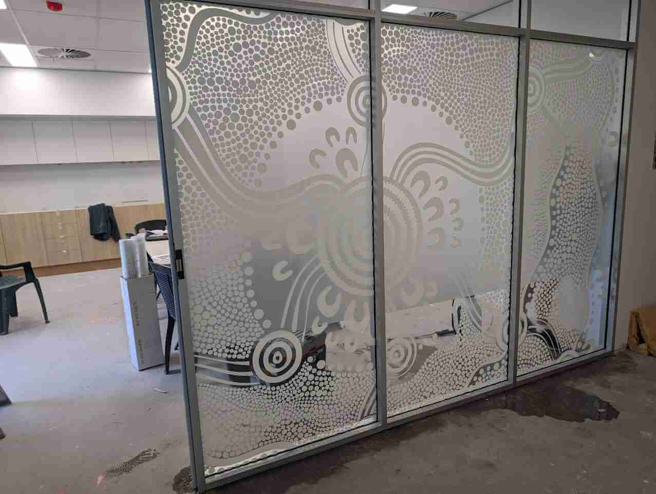 Decorative frosted glass panels with custom patterned graphics in office space