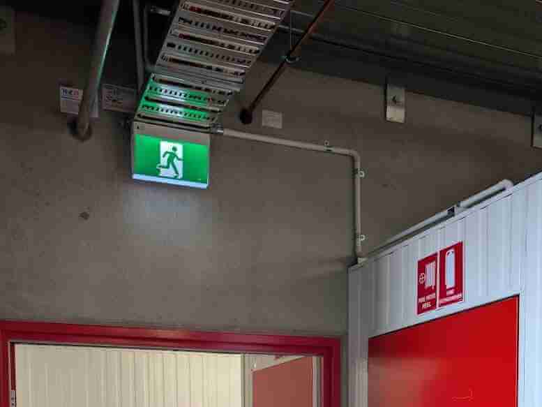 Red fire hose reel door with EXIT signage installed in commercial building