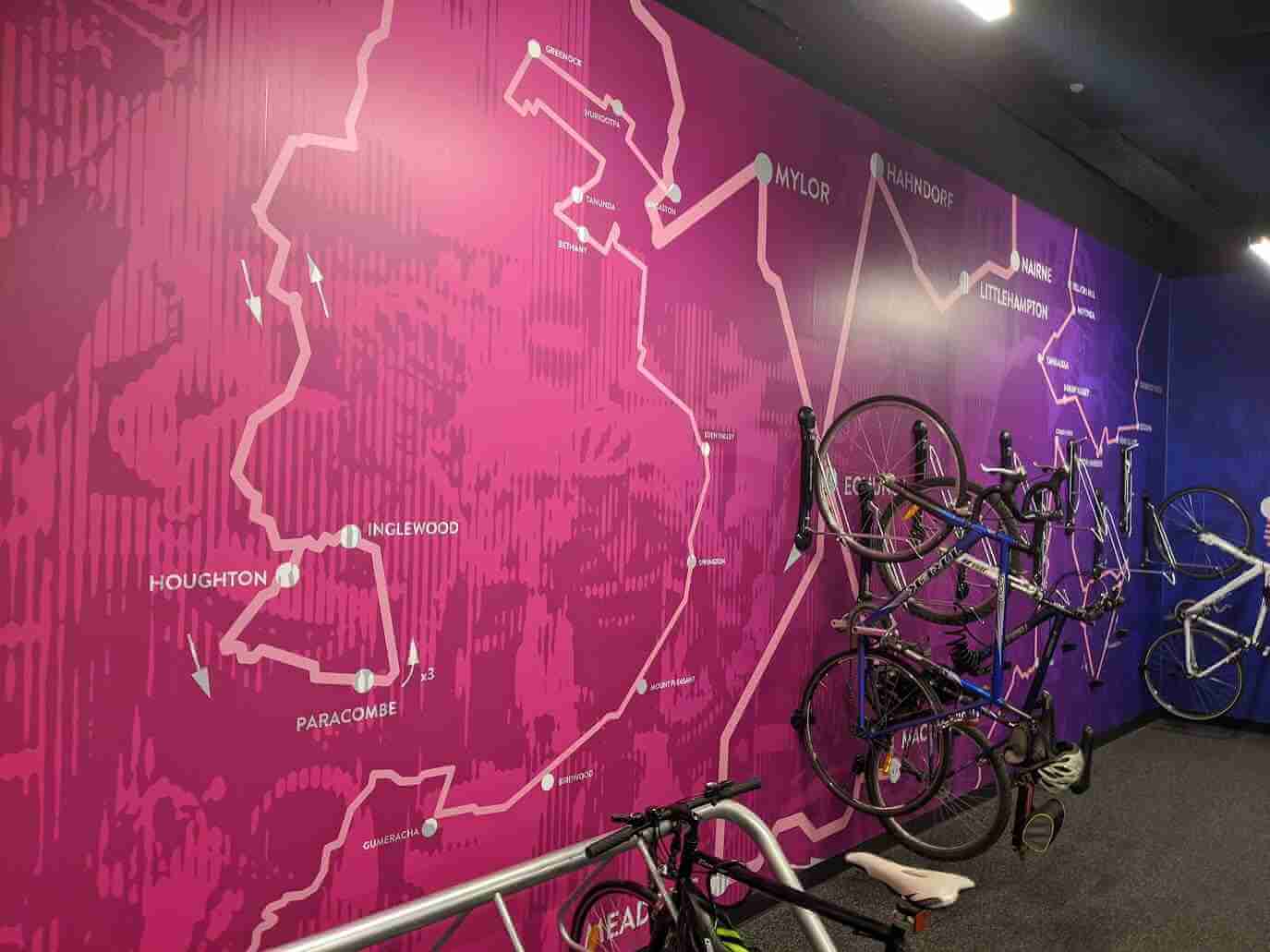 Pink and purple wall graphic featuring cycling route and bicycle storage area