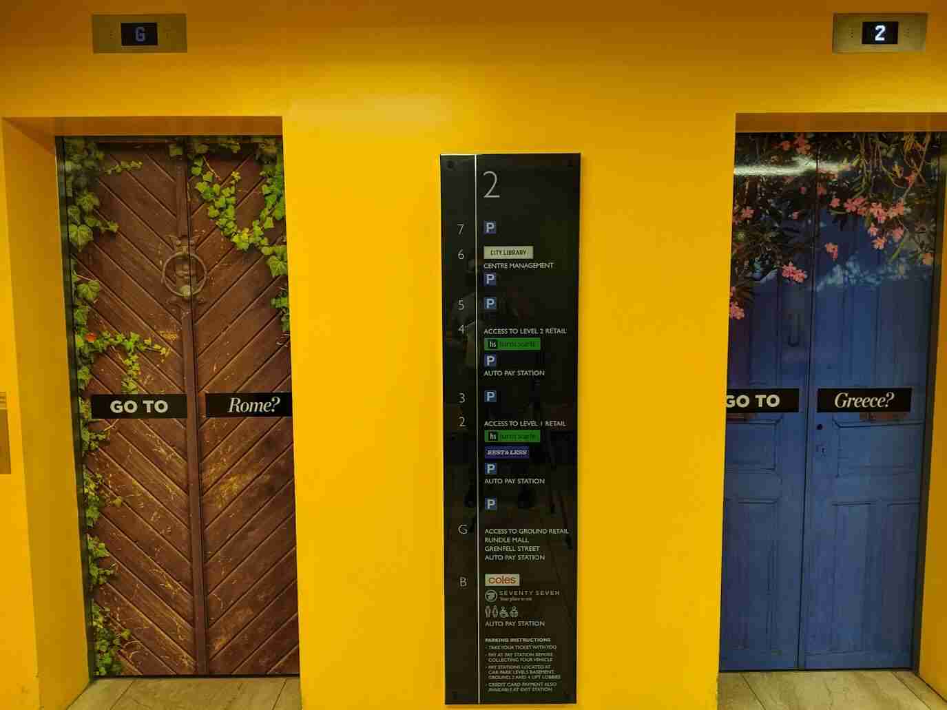 Vertical building directory sign mounted on yellow interior wall