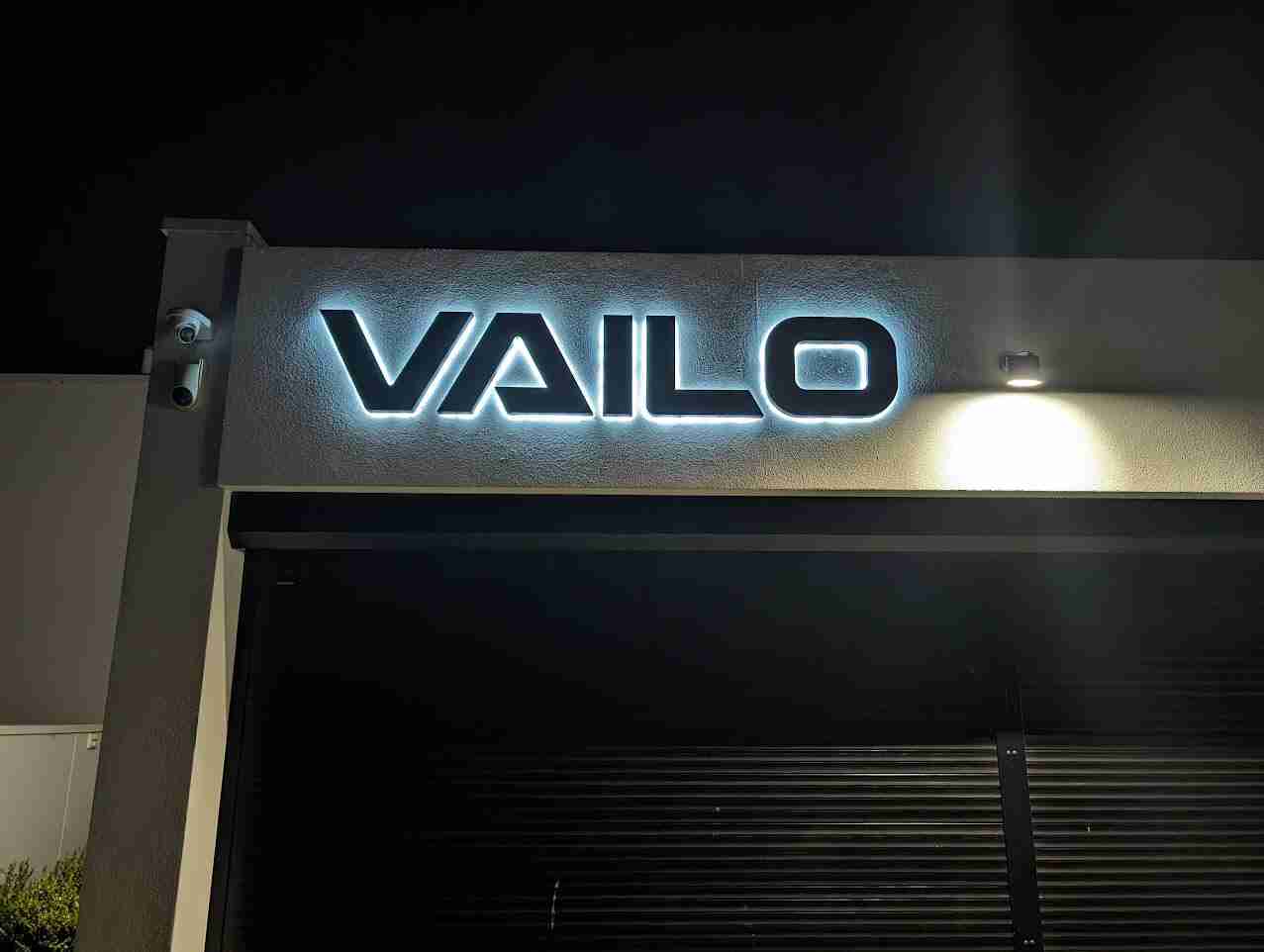 Illuminated sign reading 'VAILO' at night