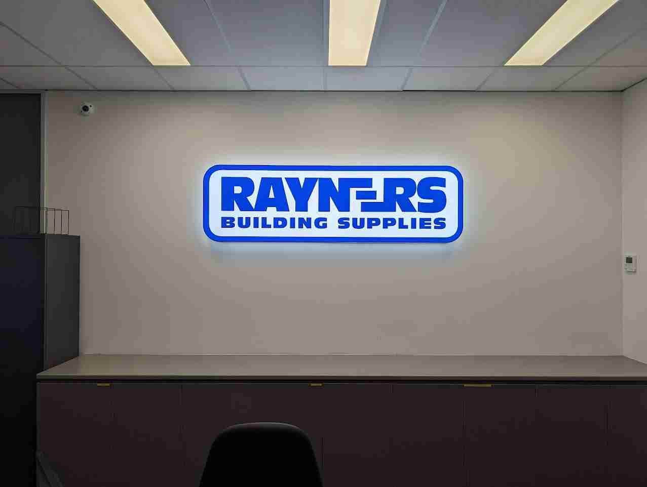 Front view of Rayners Building Supplies illuminated indoor signage