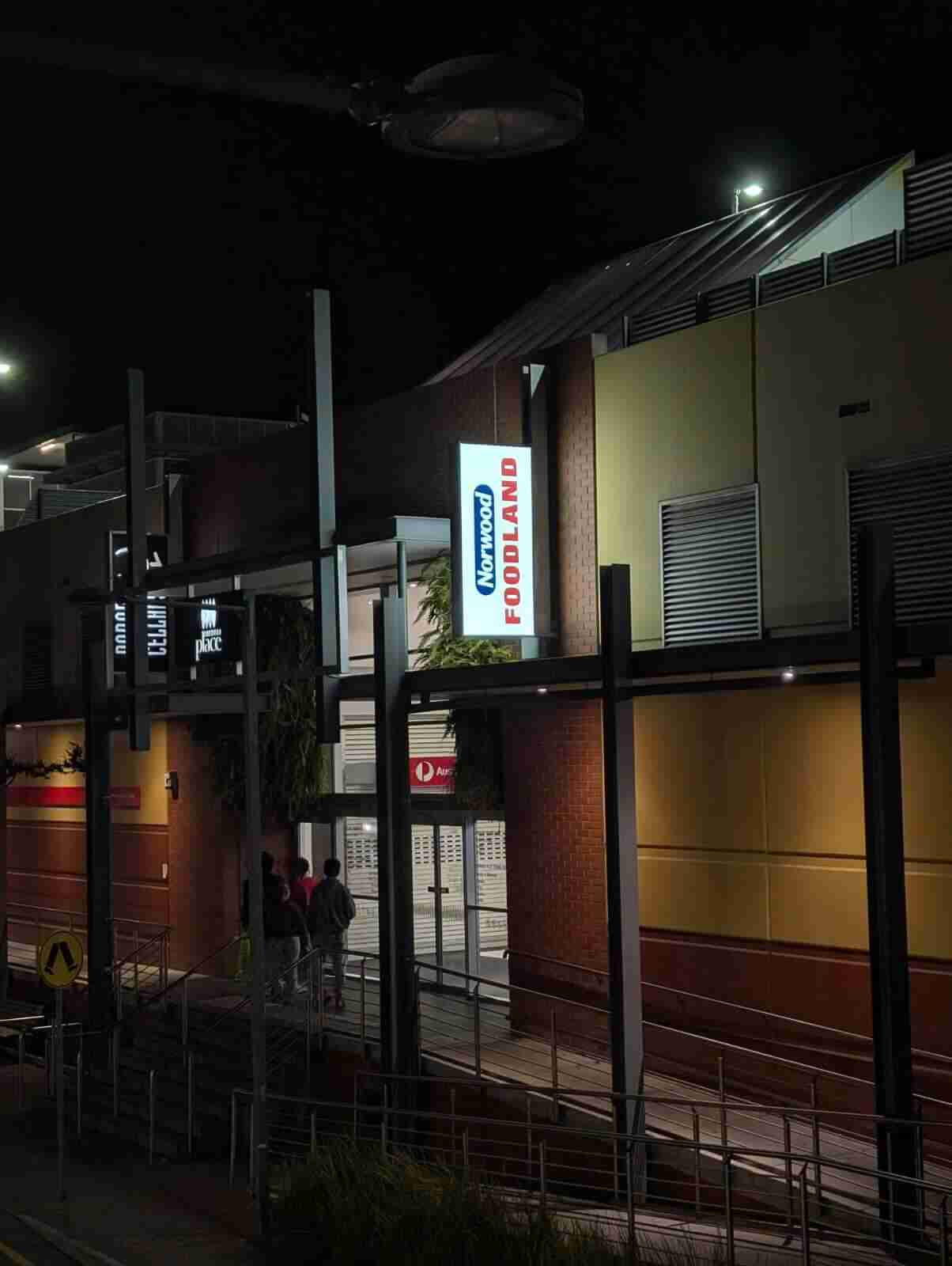 Illuminated Foodland shopfront signage lit at night