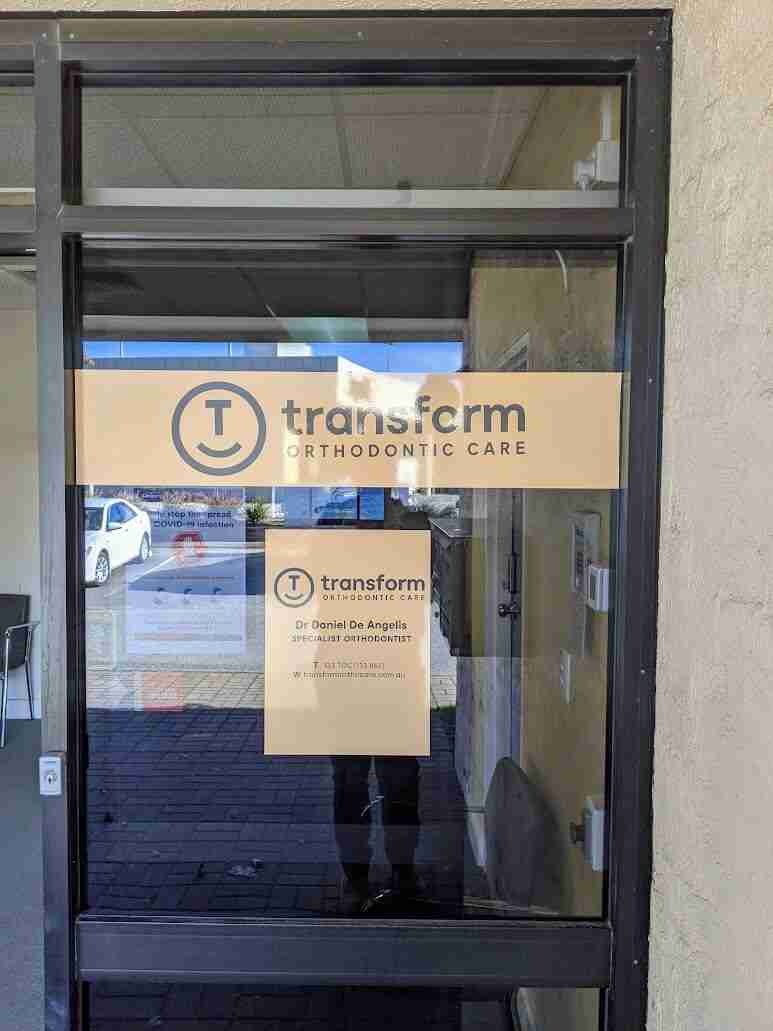 Transform Orthodontic Care glass door signage with clinic details and logo