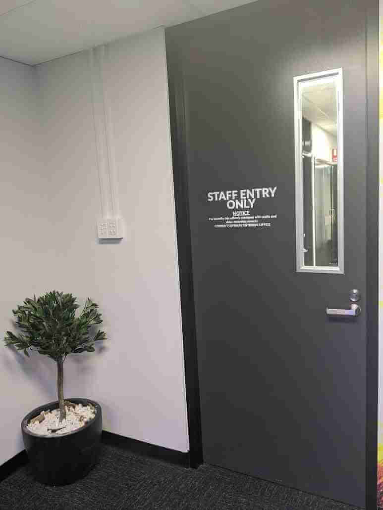 Specialty Training Room silver door sign applied to dark office door