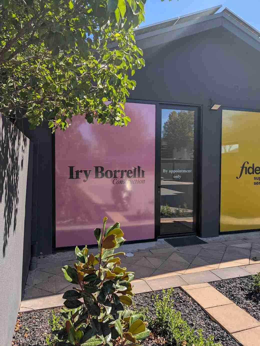 Iry Borrellis shopfront window graphics in pink and yellow branding panels