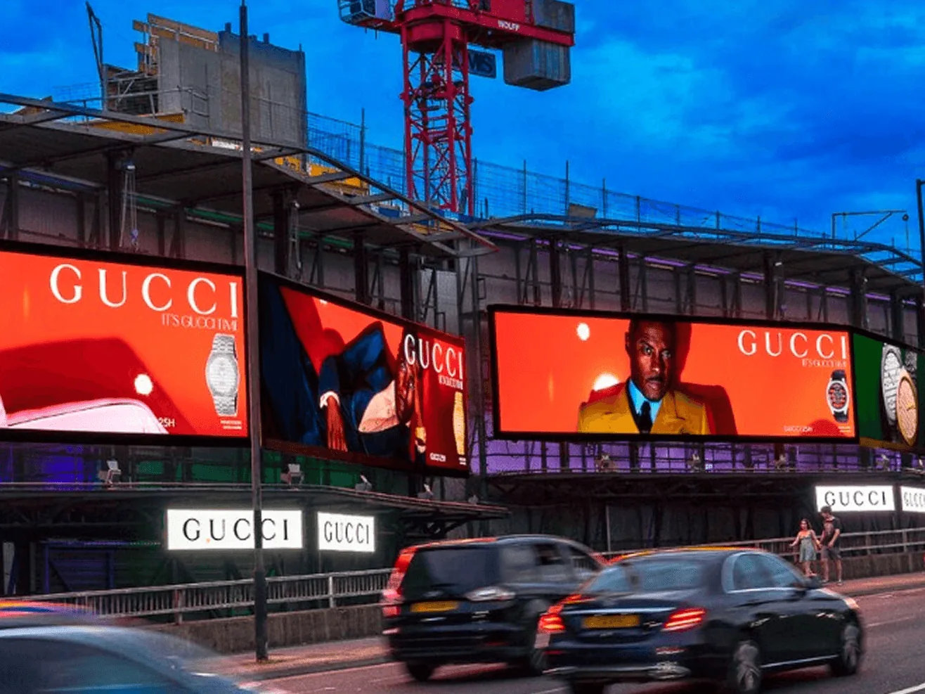 Large digital billboards displaying advertising above busy city street at dusk