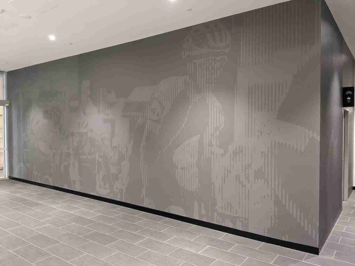 Monochrome illustrative wall graphic covering long interior corridor wall