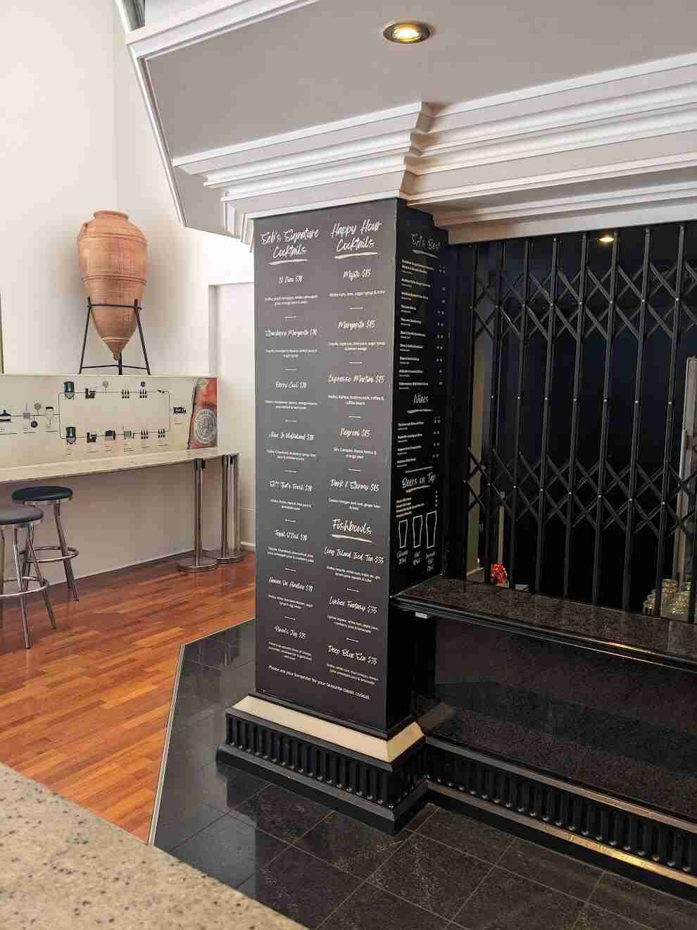 Vertical black menu wall graphic featuring café food and drink listings