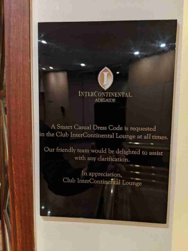 Premium black acrylic plaque with gold lettering installed in a corporate office